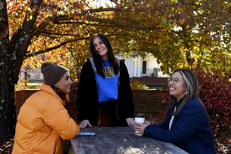 Three students sit outside on MSU campus.