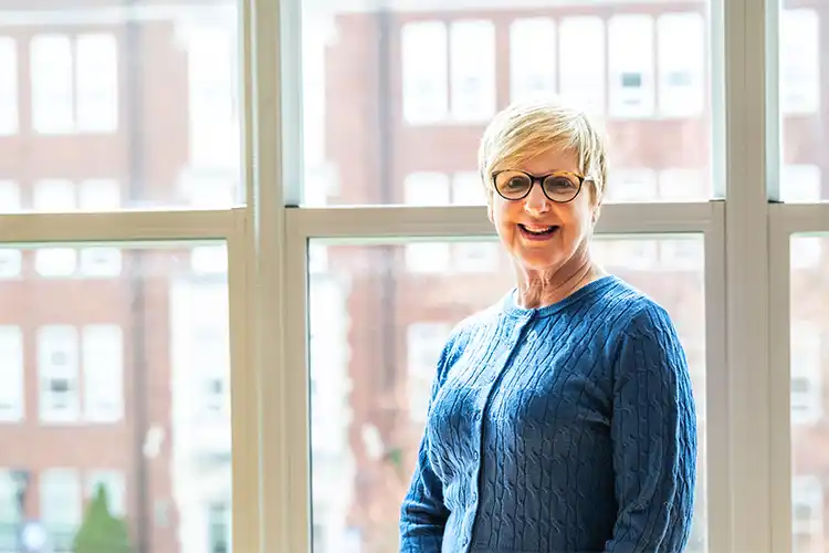 Picture of Donell Murray standing in front of a window looking at camera.