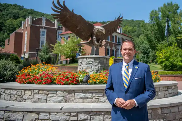 President Jay Morgan in front of the Eagle Statue on campus