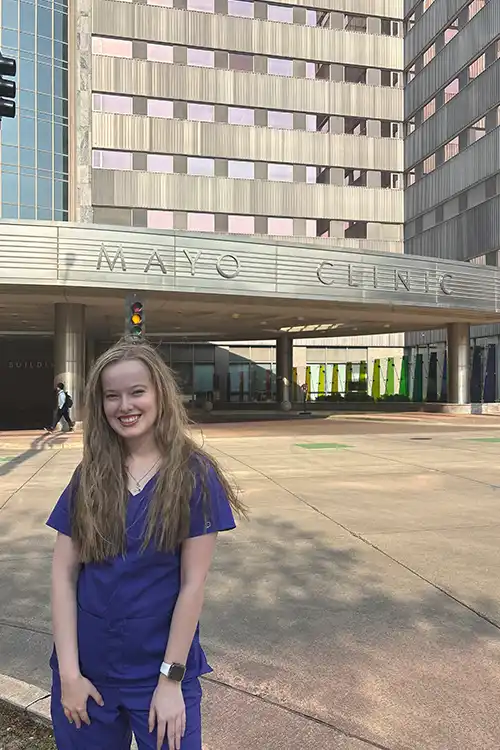 Meredith Hennion in nursing scrubs in front of Mayo Clinic.