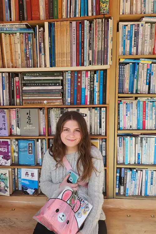 Rose Fryman sitting in front of a book shelf.