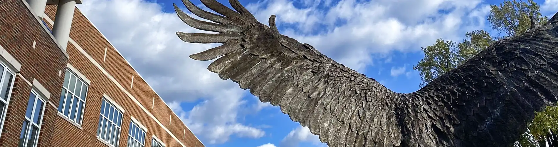 View of Eagle Sculpture from the back with blue sky and clouds overhead