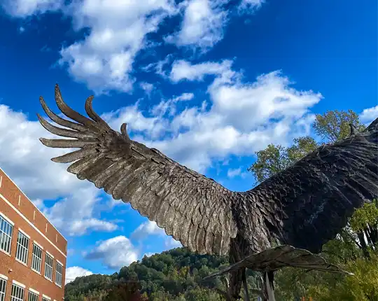 View of Eagle Sculpture from the back with blue sky and clouds overhead